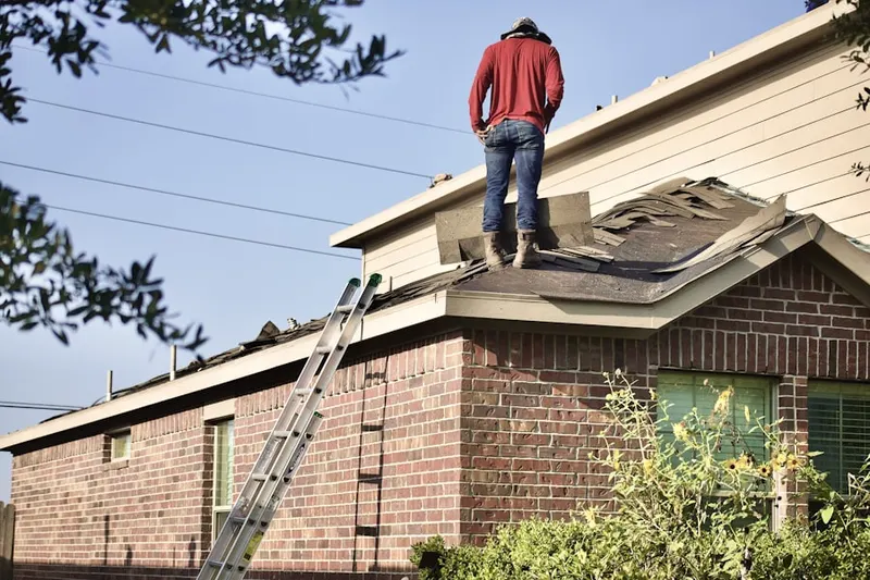 Professional roofer working on a residential roof in Willis
